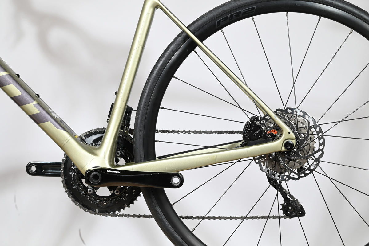 Gros plan sur le cadre en carbone champagne et la transmission Shimano du vélo de route Giant Defy Advanced 2 Loop Sports