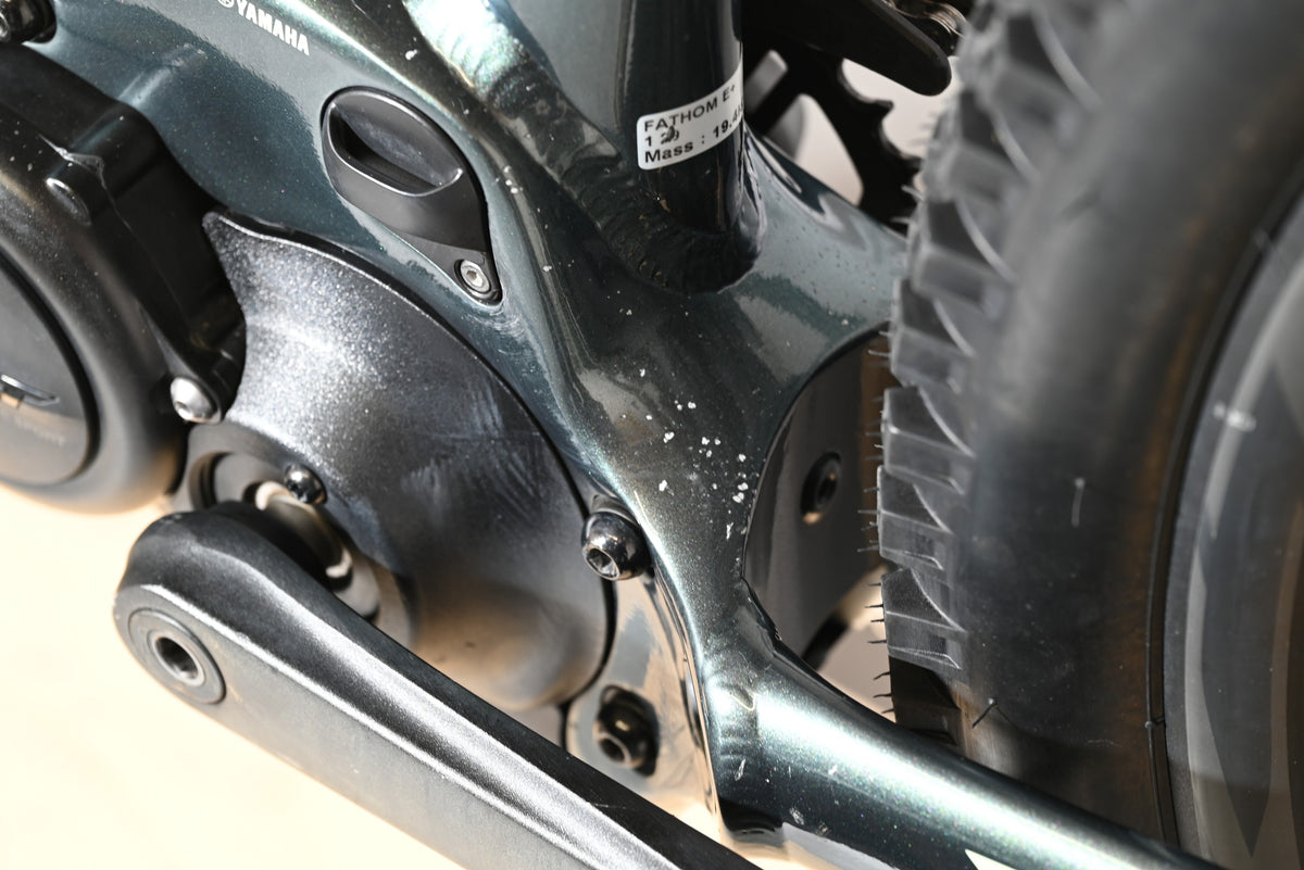 Gros plan sur le cadre et le moteur Yamaha d'un vélo électrique Giant Fathom E+1 Loop Sports avec traces d'usure