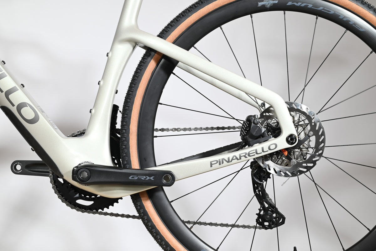 Gros plan sur le cadre blanc et la transmission Shimano GRX du vélo gravel Pinarello Grevil F1 chez Loop Sports