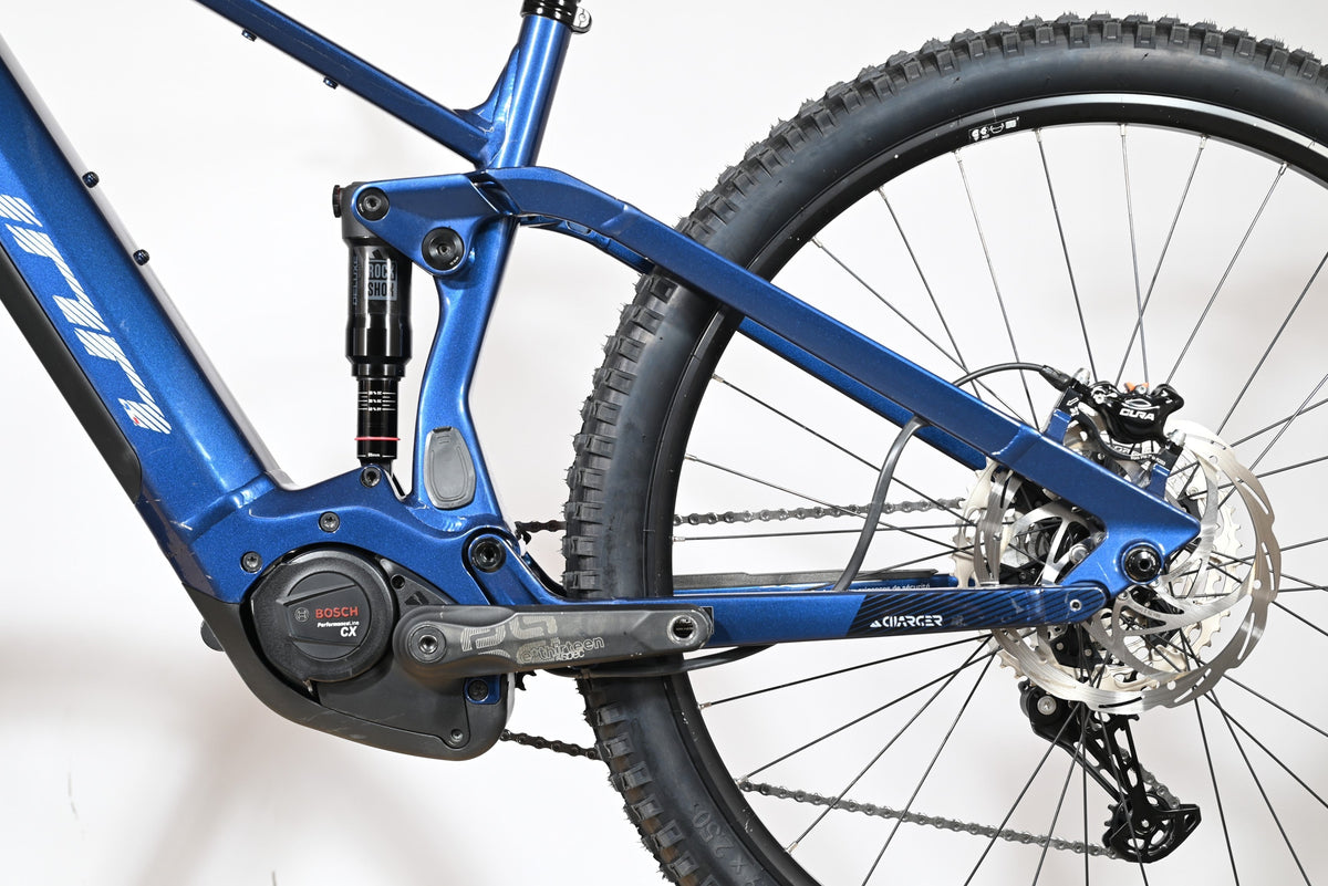 Gros plan sur le cadre bleu et la suspension arrière RockShox du vélo électrique Loop Sports Sunn Charger S1 2025