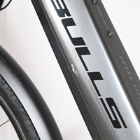 Gros plan sur le cadre gris du vélo électrique Loop Sports Bulls Cross Evo Lite 1 avec une légère éraflure visible.