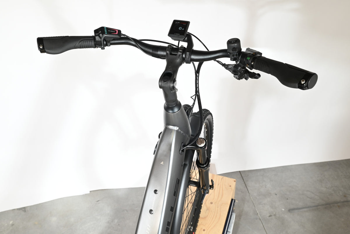 Vue rapprochée du guidon et de l'écran Bosch d'un vélo électrique Loop Sports Bulls Cross Evo Lite 1 gris