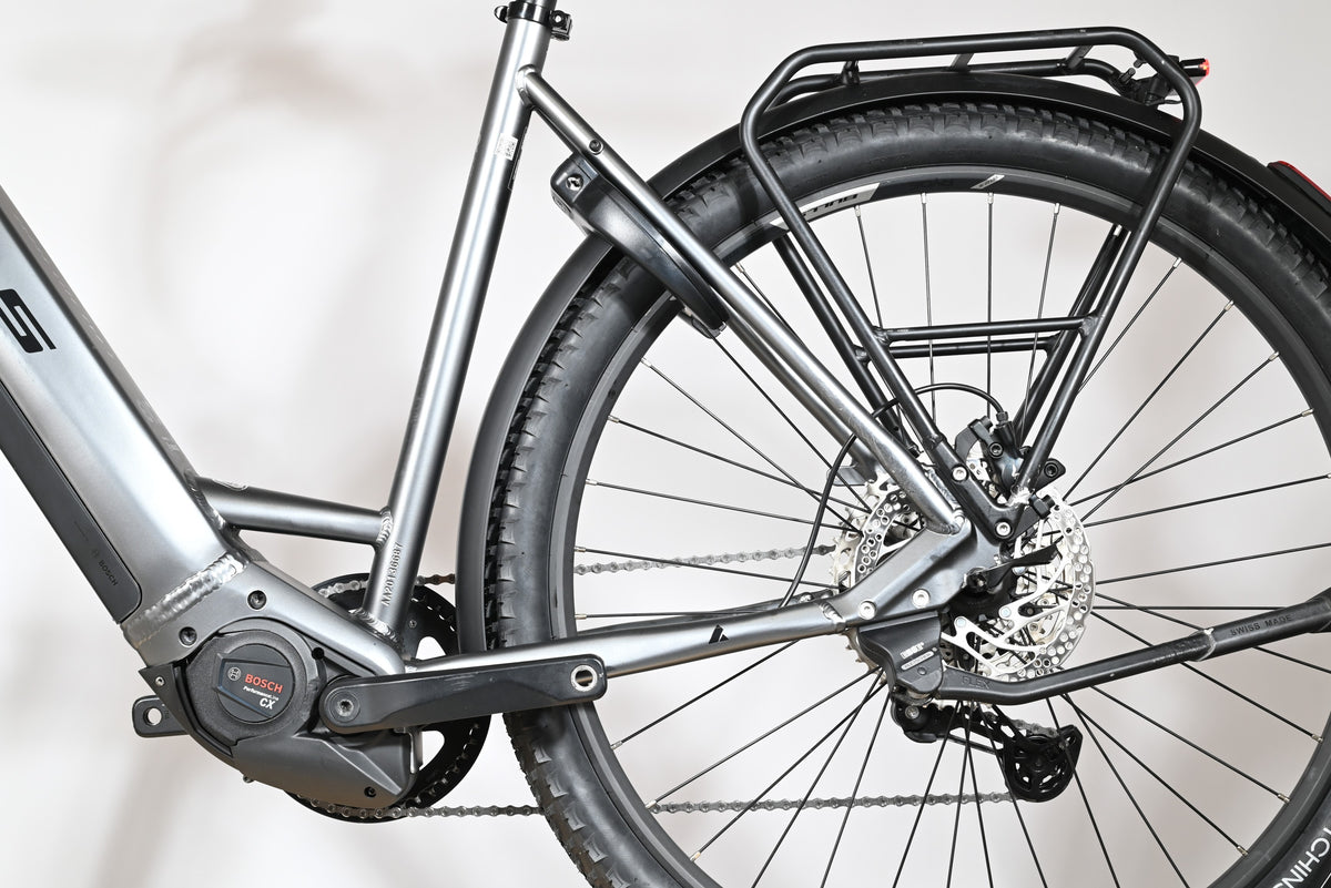 Gros plan sur le cadre gris et la roue arrière du vélo électrique Loop Sports Bulls Cross Evo Lite 1 avec porte-bagages