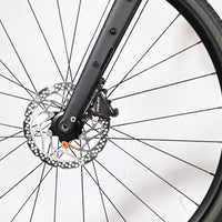 Gros plan sur le frein à disque hydraulique Shimano GRX et la fourche en carbone du vélo Loop Sports Cannondale Topstone