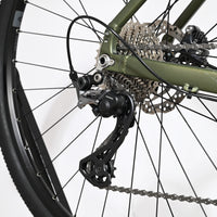 Gros plan sur le dérailleur arrière Shimano et la cassette du vélo gravel Loop Sports Carver 120 vert olive