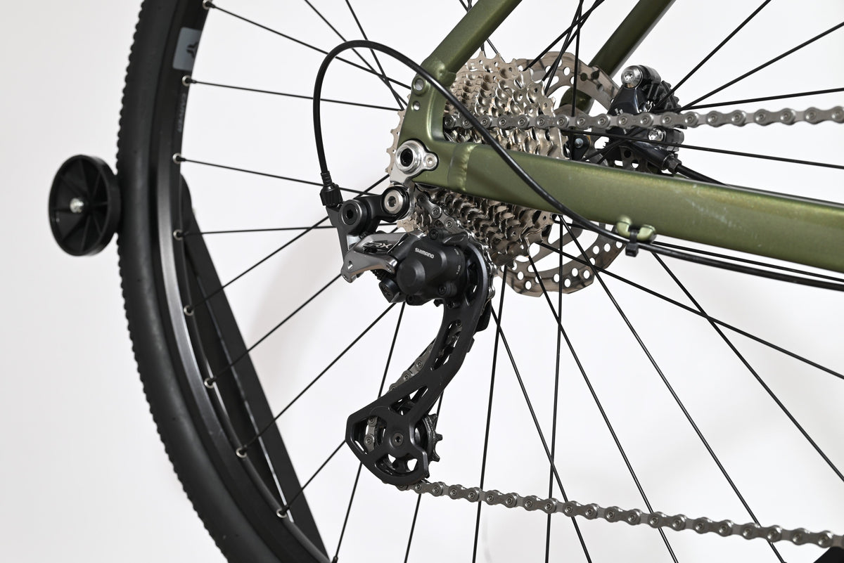 Gros plan sur le dérailleur arrière Shimano et la cassette du vélo gravel Loop Sports Carver 120 vert olive