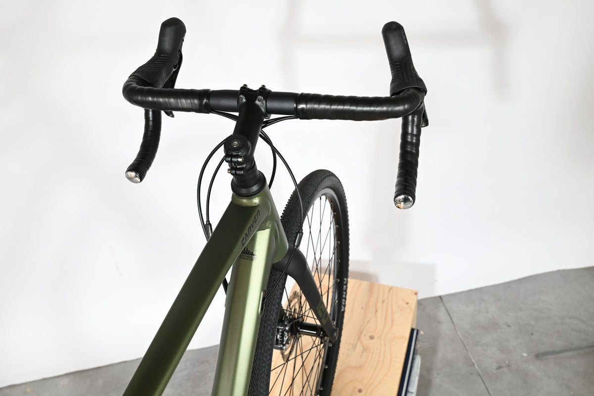 Vue plongeante sur le guidon et le cadre vert olive du vélo gravel Carver Gravel 120 de la marque Loop Sports