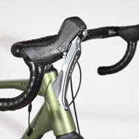 Leviers de frein Shimano GRX sur le guidon noir du vélo gravel Loop Sports Carver 120 vert olive