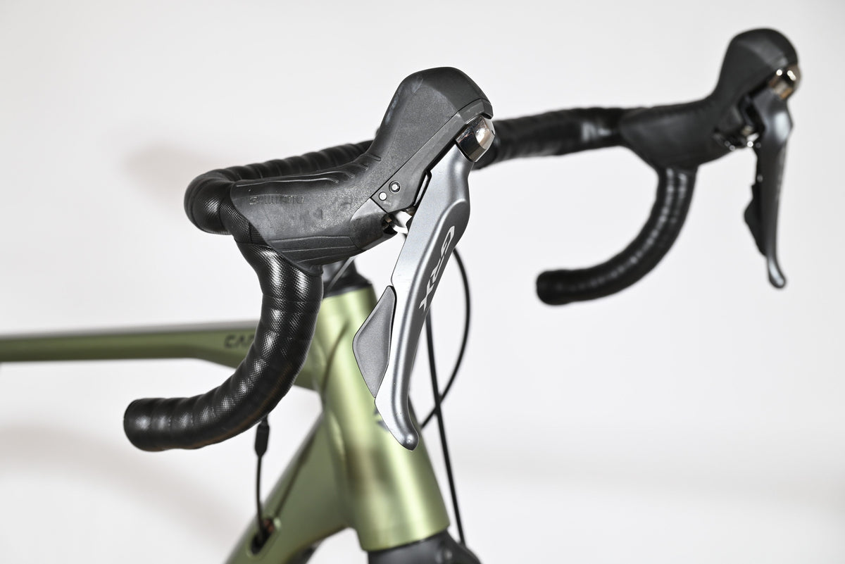 Leviers de frein Shimano GRX sur le guidon noir du vélo gravel Loop Sports Carver 120 vert olive