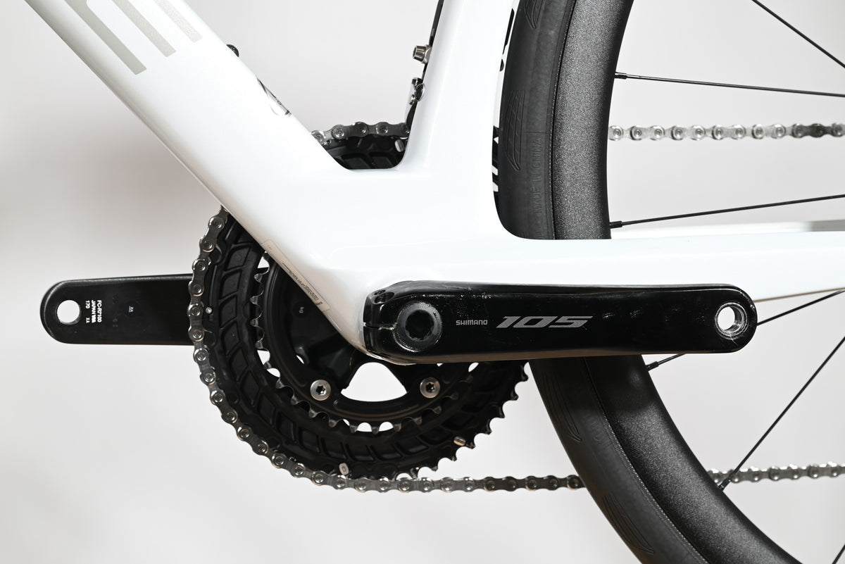 Gros plan sur le pédalier Shimano 105 et le cadre en carbone blanc du vélo de route Cube Agree C:62 One chez Loop Sports