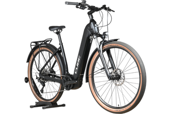 Vélo électrique Loop Sports Cube Nuride Hybrid Pro 750 noir avec pneus à flancs marron sur support en bois