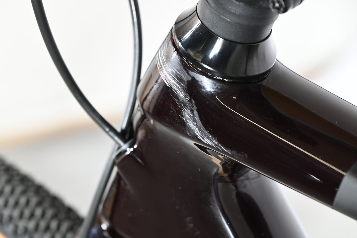 Gros plan sur une éraflure sur le cadre en carbone noir du vélo Loop Sports Cube Nuroad C:62 SLT