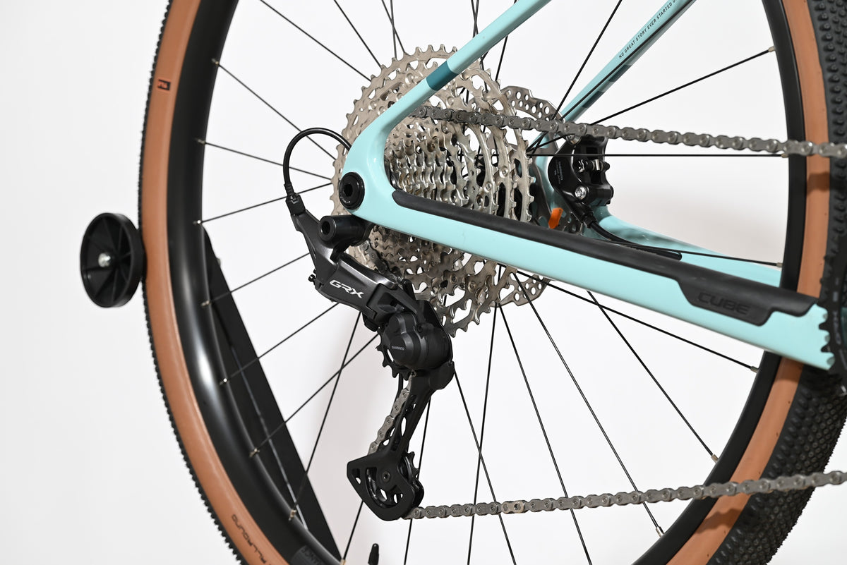Dérailleur arrière Shimano GRX sur vélo gravel Loop Sports Cube Nuroad C:62 ONE bleu clair avec pneus à flancs tan