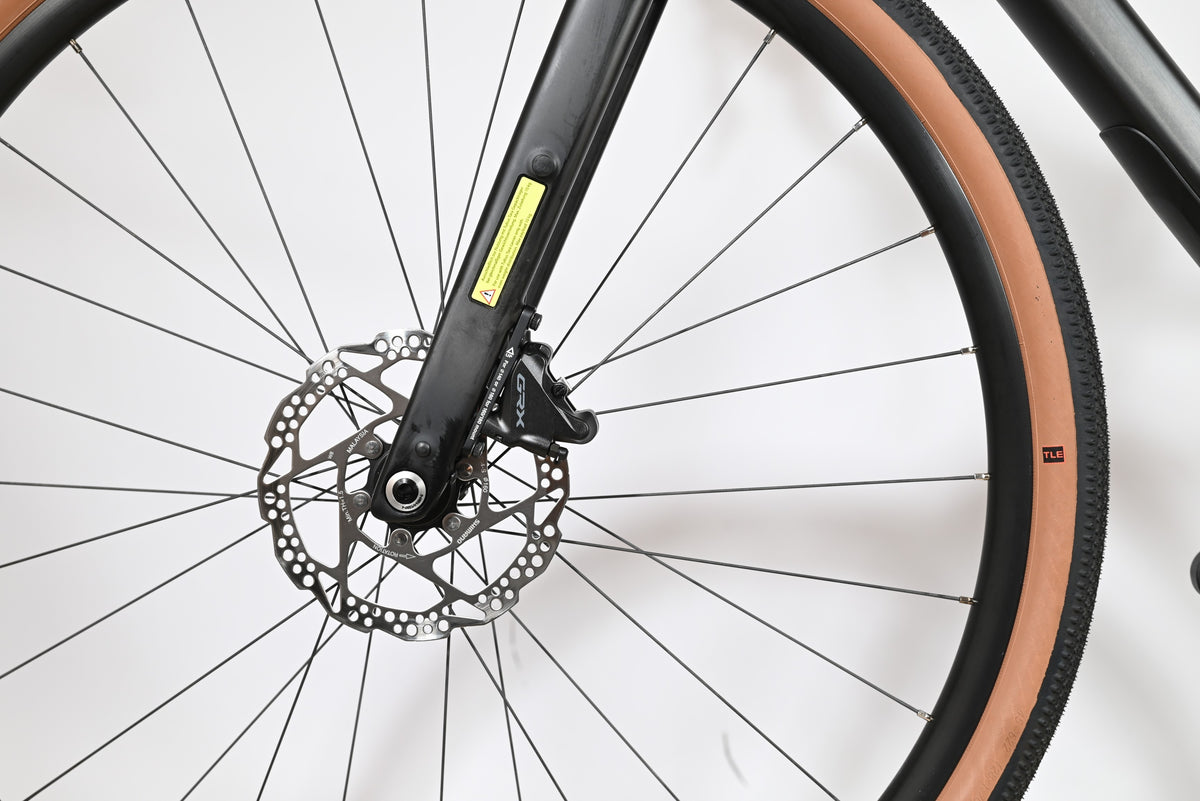 Gros plan sur la roue avant et le frein à disque hydraulique Shimano GRX du vélo gravel Cube Nuroad C:62 ONE Loop Sports