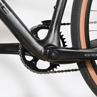 Gros plan sur le pédalier Shimano GRX et le cadre en carbone noir du vélo gravel Loop Sports Cube Nuroad C:62 ONE
