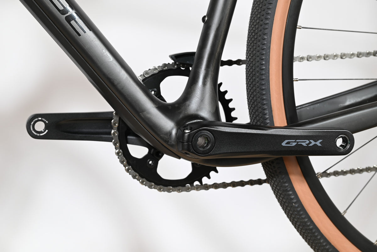 Gros plan sur le pédalier Shimano GRX et le cadre en carbone noir du vélo gravel Loop Sports Cube Nuroad C:62 ONE