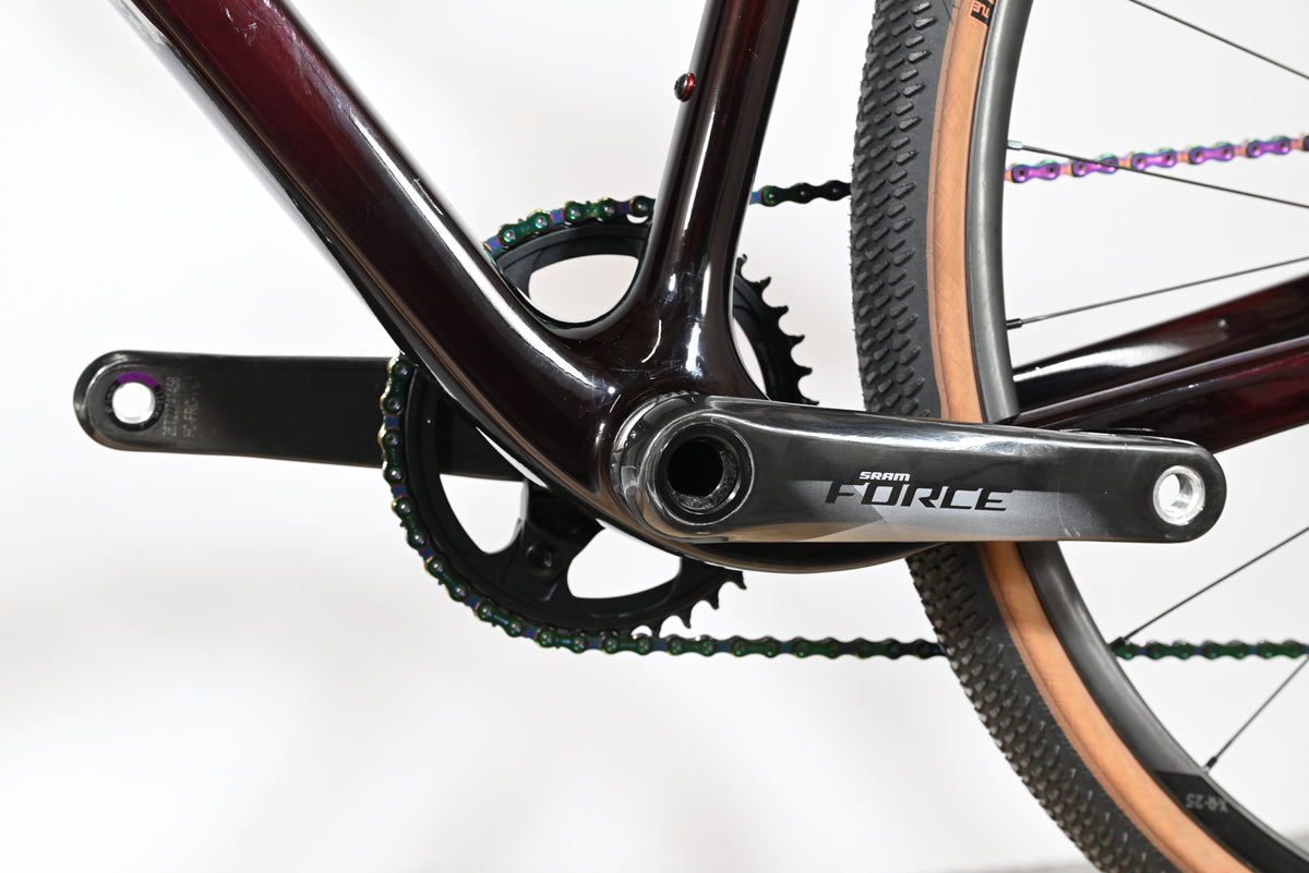 Gros plan sur le pédalier SRAM Force et la chaîne irisée du vélo gravel Cube Nuroad C:62 SLT chez Loop Sports