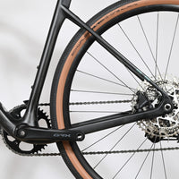Gros plan sur la transmission et la roue arrière du vélo gravel Loop Sports Cube Nuroad C:62 ONE noir avec pneus tan