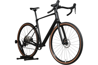 Vélo de gravel Loop Sports Cube Nuroad C:62 ONE 2025 noir mat avec pneus à flancs marron sur support en bois
