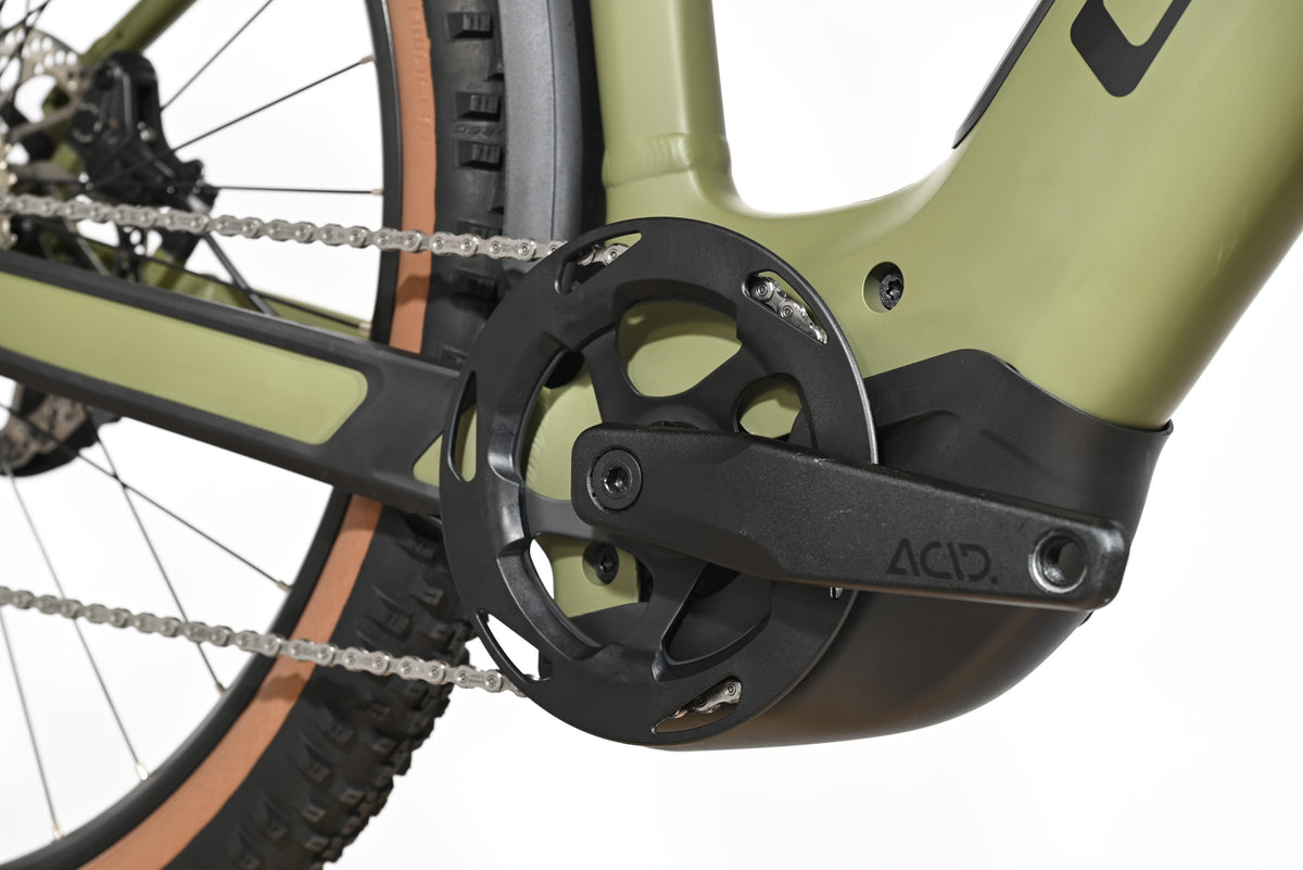Gros plan sur le pédalier noir ACID et le cadre vert olive du vélo électrique Cube Reaction Hybrid Race 750 Loop Sports