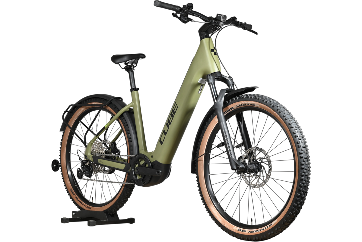 Vélo électrique Cube Reaction Hybrid Race 750 vert olive de Loop Sports avec pneus à flancs marron sur support bois