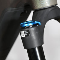 Gros plan sur la fourche avant du vélo électrique Loop Sports Cube Stereo Hybrid avec réglage bleu et autocollant QR