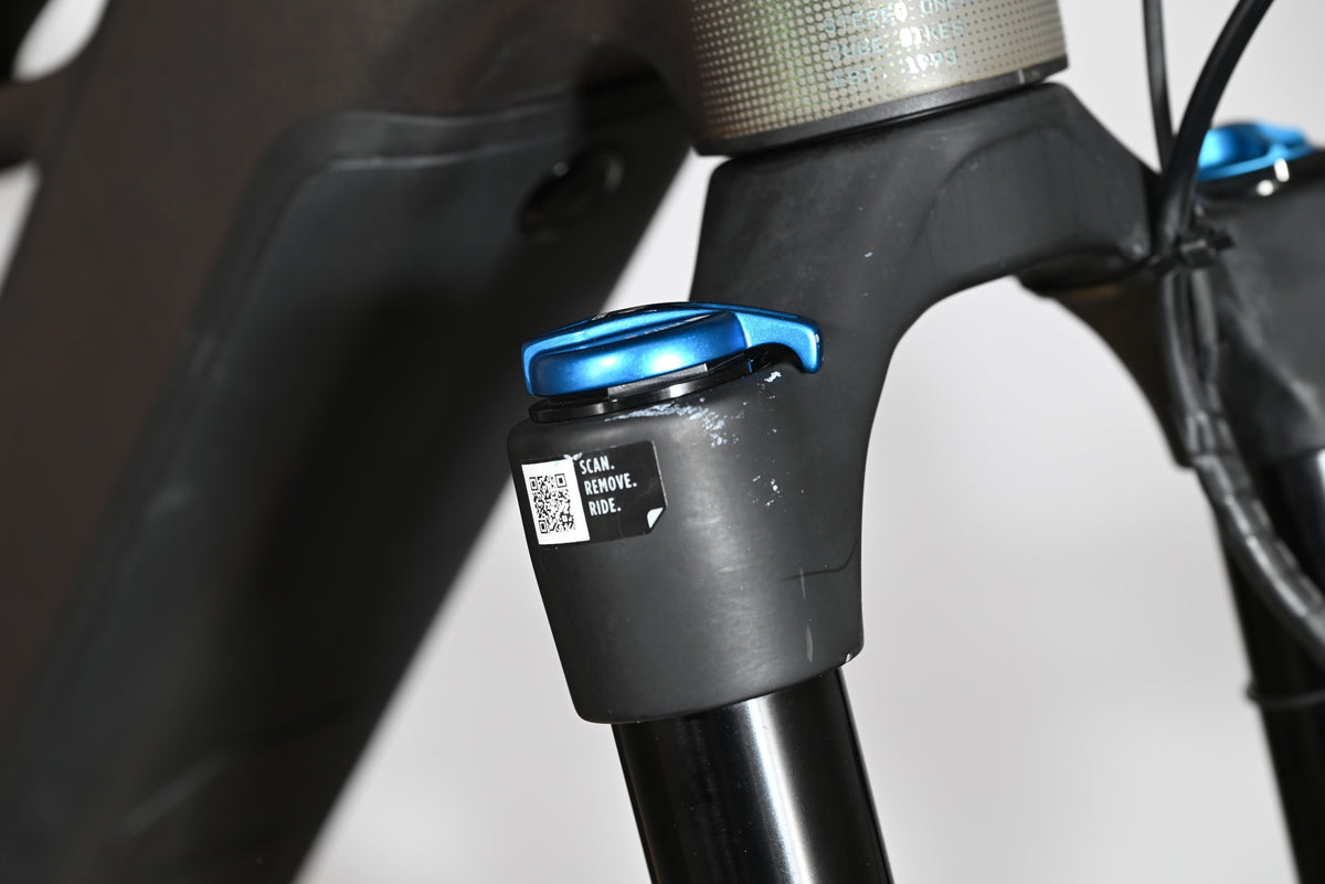 Gros plan sur la fourche avant du vélo électrique Loop Sports Cube Stereo Hybrid avec réglage bleu et autocollant QR