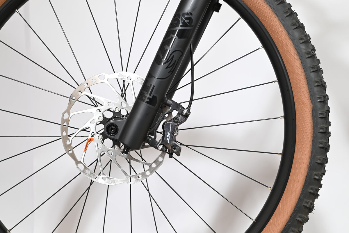 Gros plan sur le frein à disque hydraulique et la fourche noire du vélo électrique Cube Stereo Hybrid Loop Sports