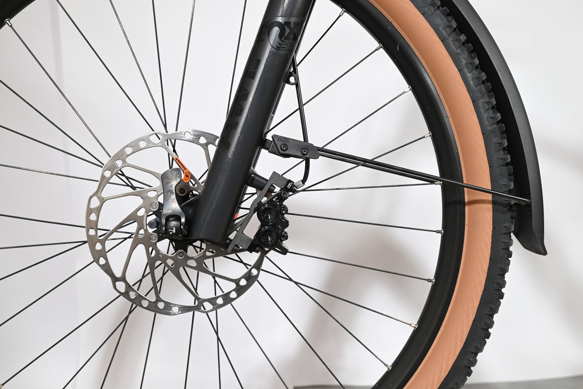 Gros plan sur la roue avant et le frein à disque du vélo électrique Cube Stereo Hybrid 120 Race Allroad chez Loop Sports