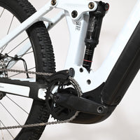 Gros plan sur le cadre blanc et l'amortisseur arrière RockShox du vélo électrique Loop Sports Cube Stereo Hybrid 140