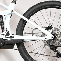 Vue rapprochée du cadre blanc et de la suspension arrière du vélo électrique Loop Sports Cube Stereo Hybrid 140