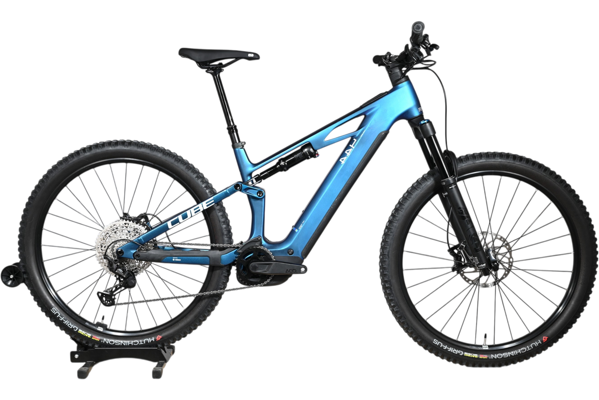 Velo electrique tout-terrain Cube Stereo Hybrid ONE44 HPC SLX 800 bleu de Loop Sports sur socle en bois