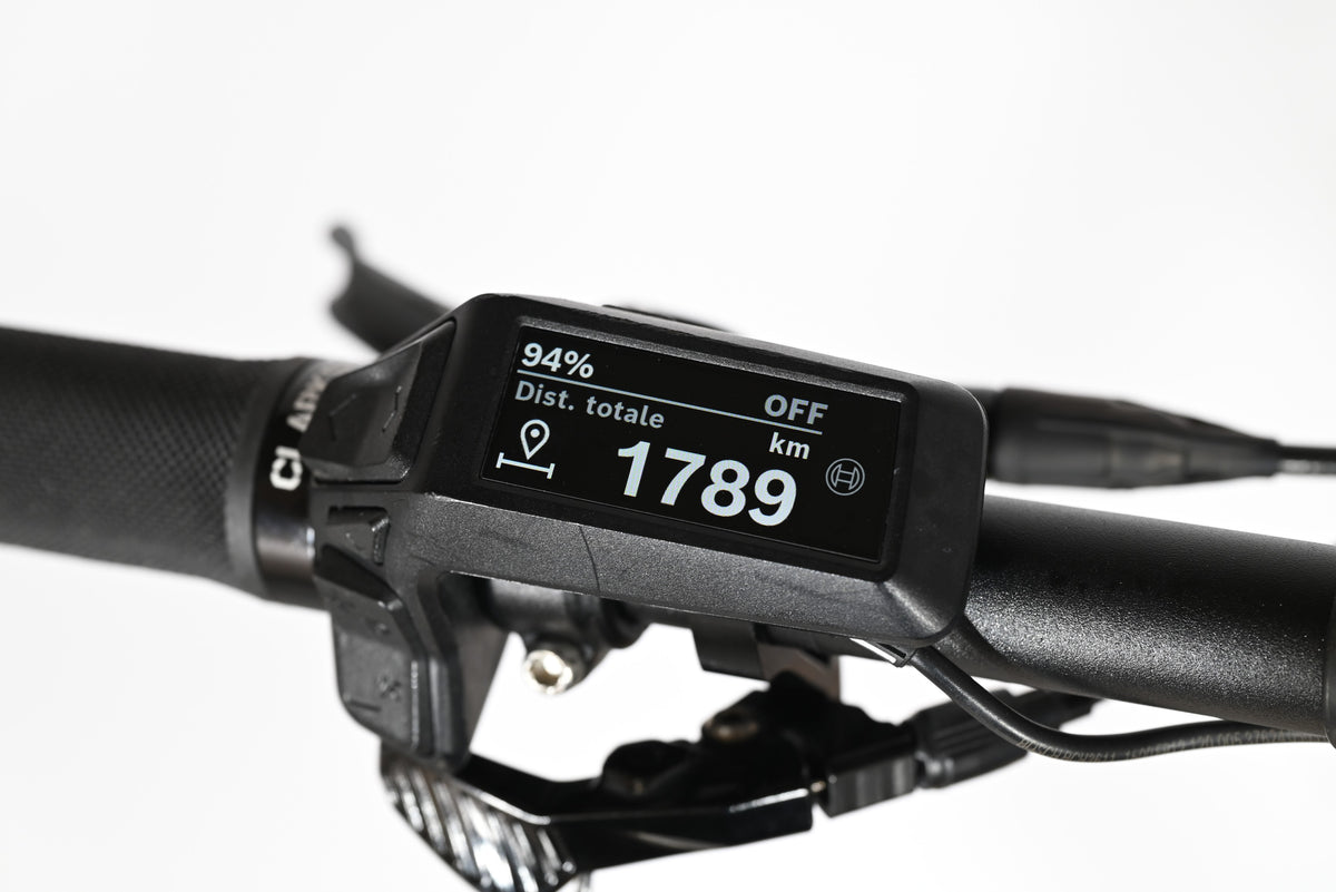 Écran de contrôle Bosch noir monté sur le guidon d'un vélo électrique Loop Sports affichant 1789 km