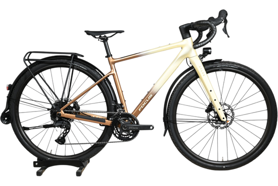 Vélo gravel Loop Sports Focus Atlas 6.8 EQP avec cadre dégradé crème et bronze, porte-bagages et garde-boue