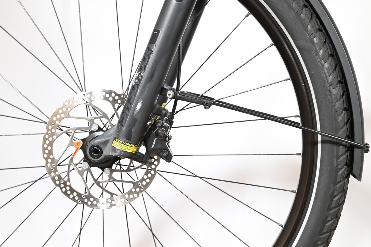 Gros plan sur la roue avant et le frein à disque hydraulique du vélo électrique Focus Aventura 6.8 de Loop Sports