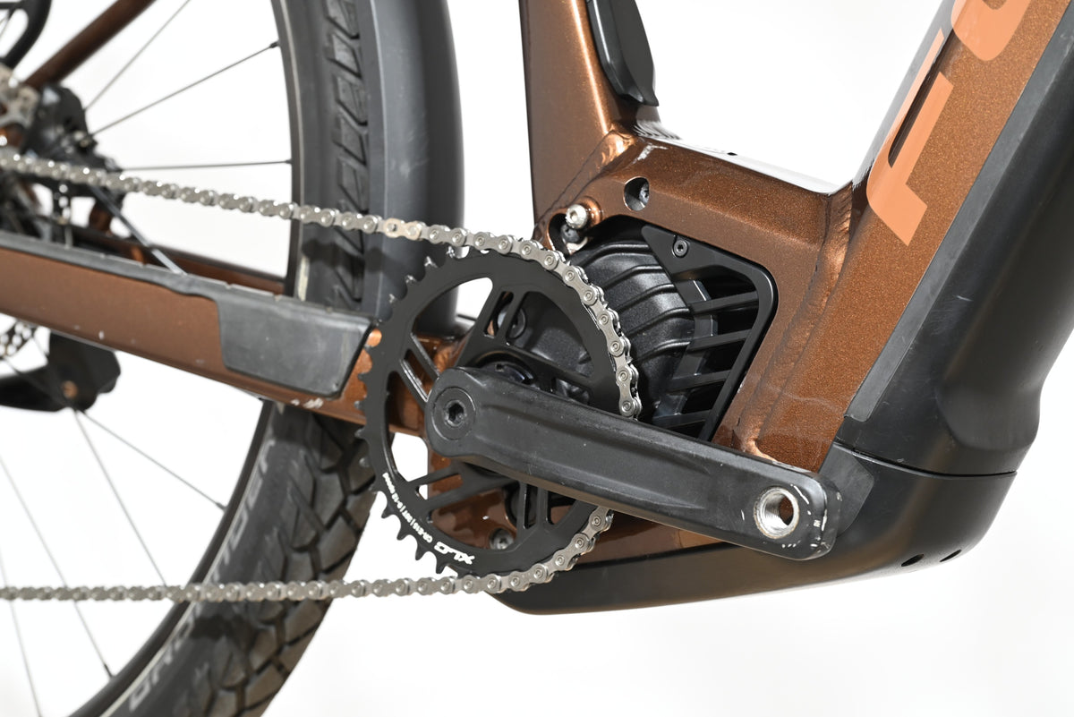 Gros plan sur le moteur et le pédalier du vélo électrique Loop Sports Focus Aventura 6.8 de couleur marron