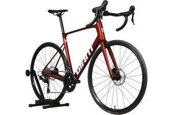 Vélo de route Giant Defy Advanced 2 2025 rouge brillant chez Loop Sports sur un support en bois