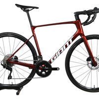 Vélo de route Giant Defy Advanced 2 2025 rouge bordeaux en carbone chez Loop Sports sur support en bois