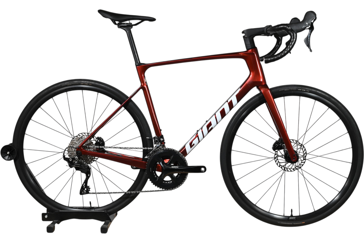 Vélo de route Giant Defy Advanced 2 2025 rouge bordeaux en carbone chez Loop Sports sur support en bois