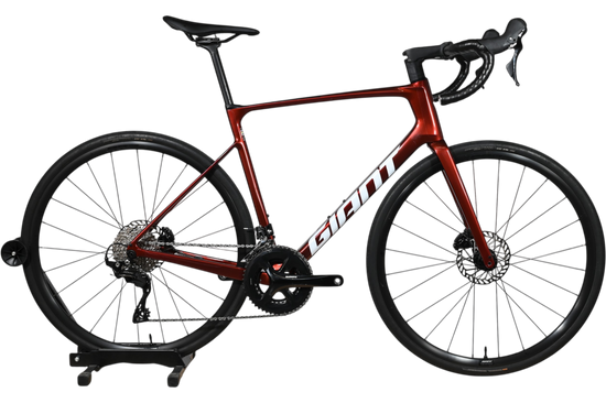Vélo de route Giant Defy Advanced 2 2025 rouge bordeaux en carbone chez Loop Sports sur support en bois