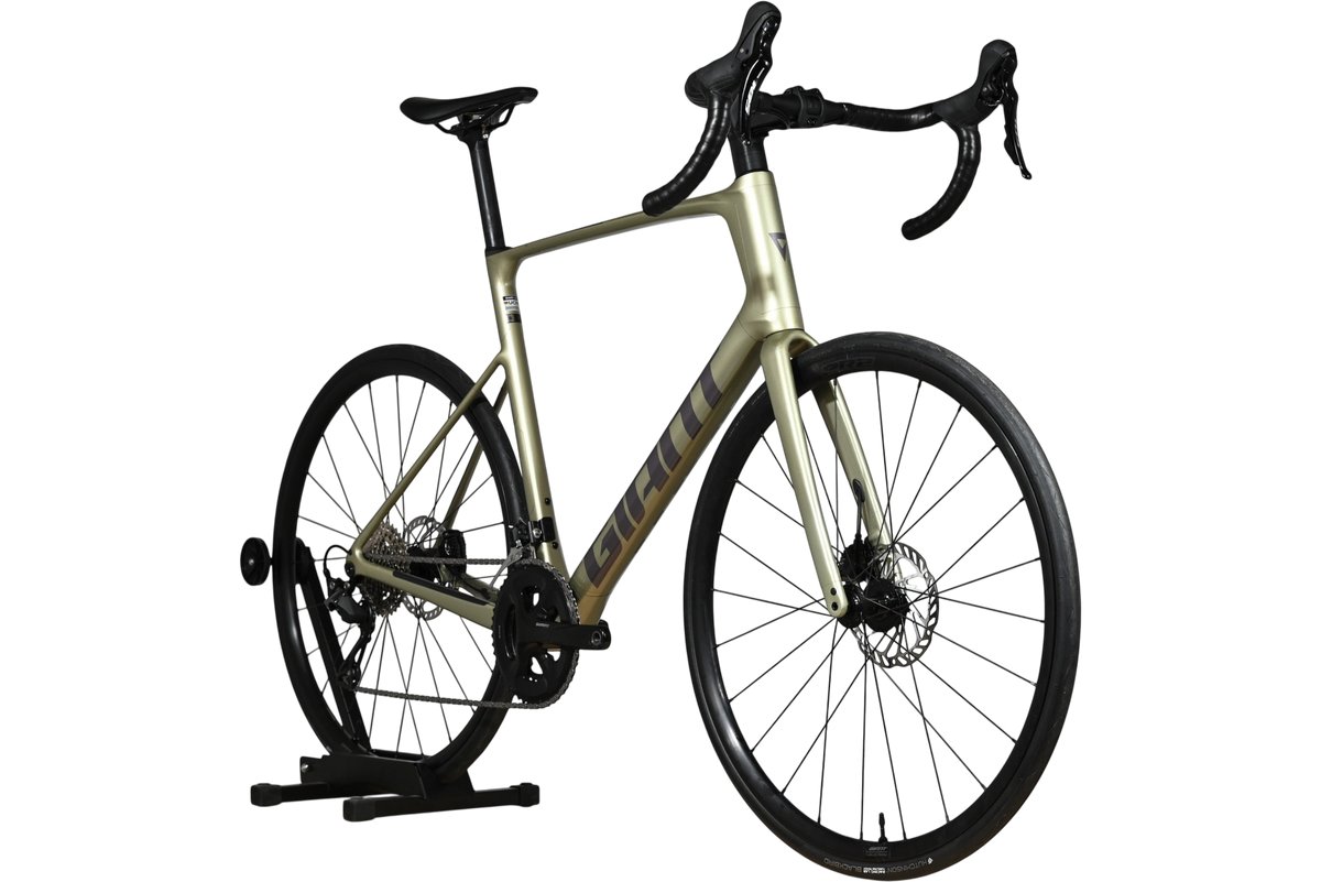Vélo de route Giant Defy Advanced 2 2024 couleur champagne chez Loop Sports sur support en bois