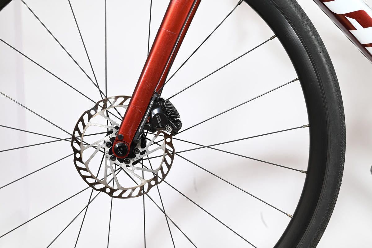 Gros plan sur le frein à disque hydraulique et la fourche rouge du vélo de route Giant Defy Advanced 2 Loop Sports