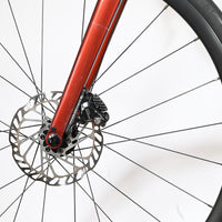 Gros plan sur le frein à disque hydraulique et la fourche rouge métallique du vélo Giant Defy Advanced 2 Loop Sports