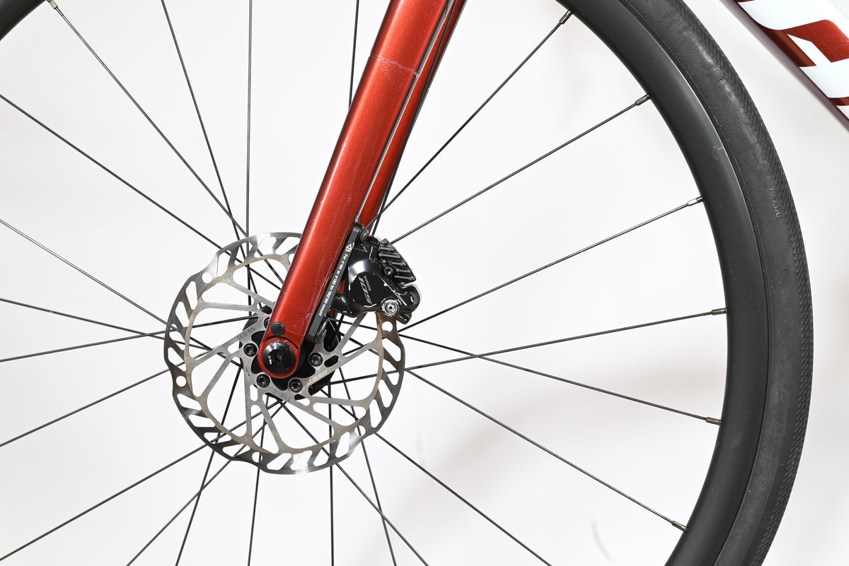 Gros plan sur le frein à disque hydraulique et la fourche rouge métallique du vélo Giant Defy Advanced 2 Loop Sports