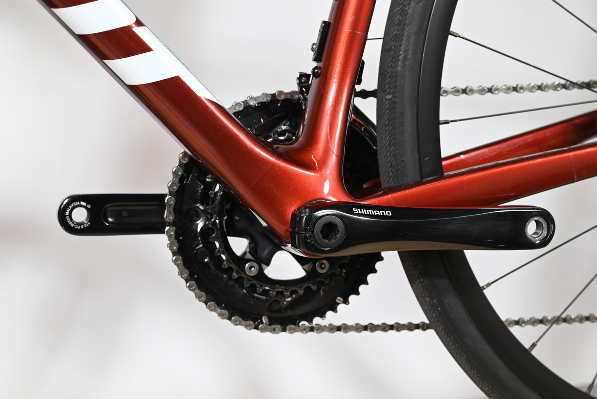 Gros plan sur le pédalier Shimano et le cadre en carbone rouge brillant du vélo de route Giant Defy Advanced 2 Loop Sports