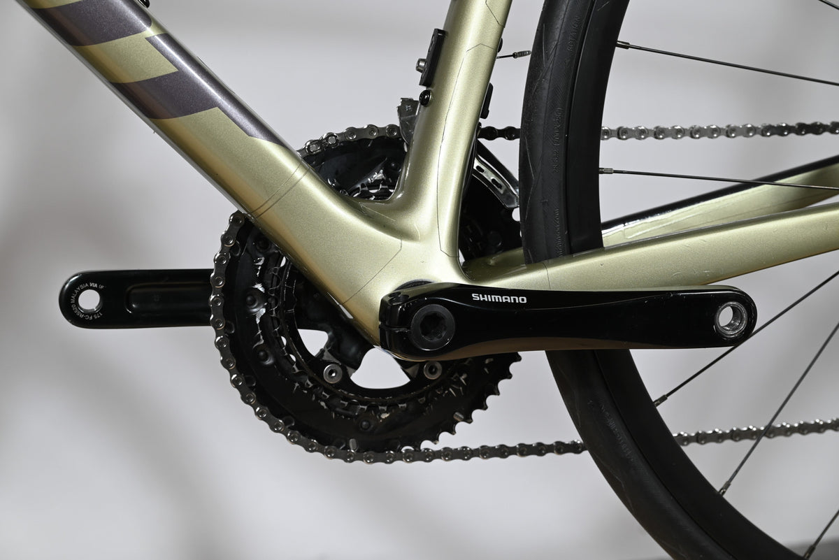 Gros plan sur le pédalier Shimano et le cadre en carbone vert olive du vélo de route Giant Defy Advanced 2 Loop Sports