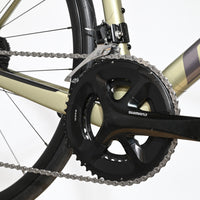 Gros plan sur le pédalier Shimano et le cadre doré du vélo de route Giant Defy Advanced 2 2024 chez Loop Sports