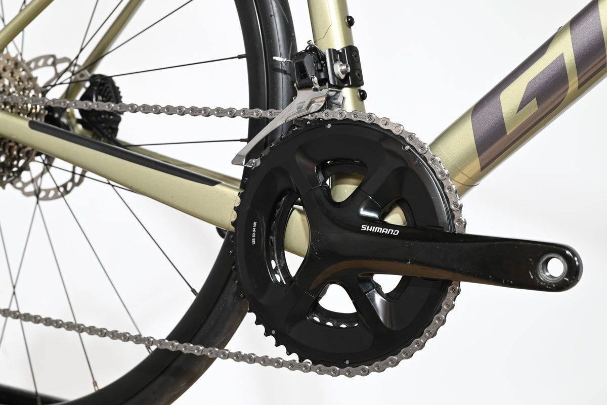 Gros plan sur le pédalier Shimano et le cadre doré du vélo de route Giant Defy Advanced 2 2024 chez Loop Sports