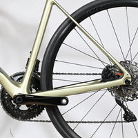 Gros plan sur le cadre en carbone champagne et la transmission Shimano du vélo de route Giant Defy Advanced 2 Loop Sports