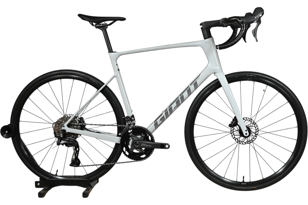Vélo de route Giant Defy Advanced 3 2026 gris clair chez Loop Sports sur un support en bois